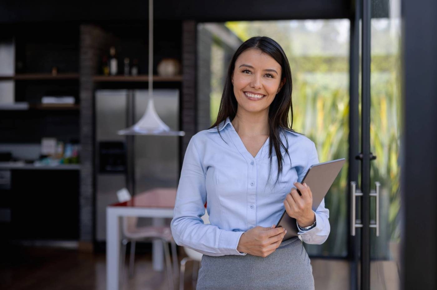 A property manager holding a tablet in a home, from Ailo’s website