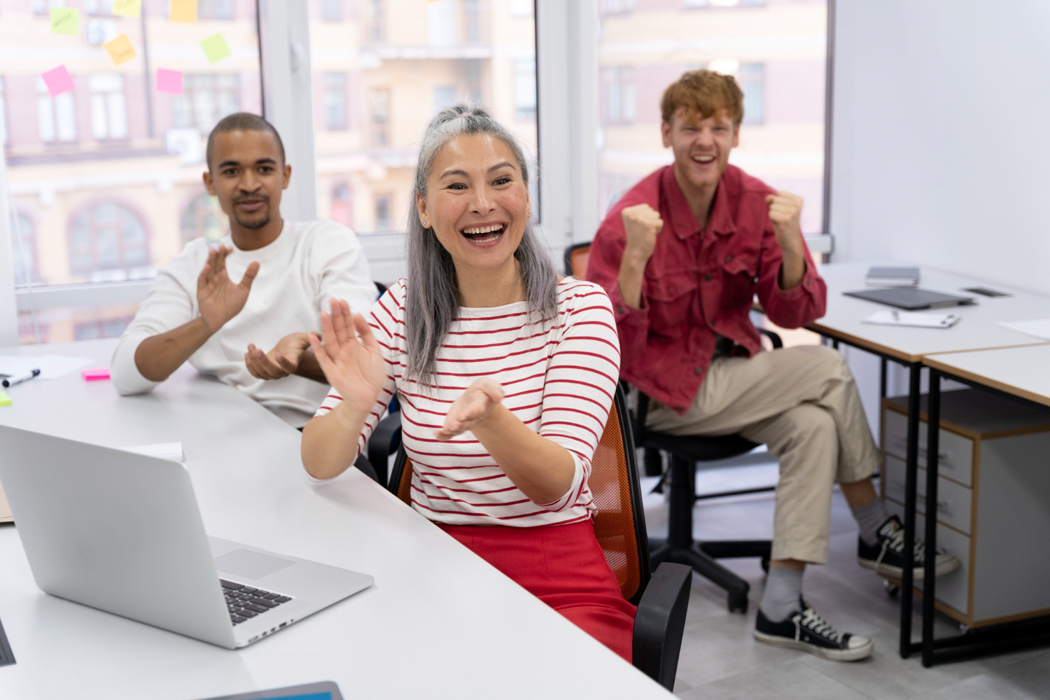 Salespeople in office clapping and celebrating sucess