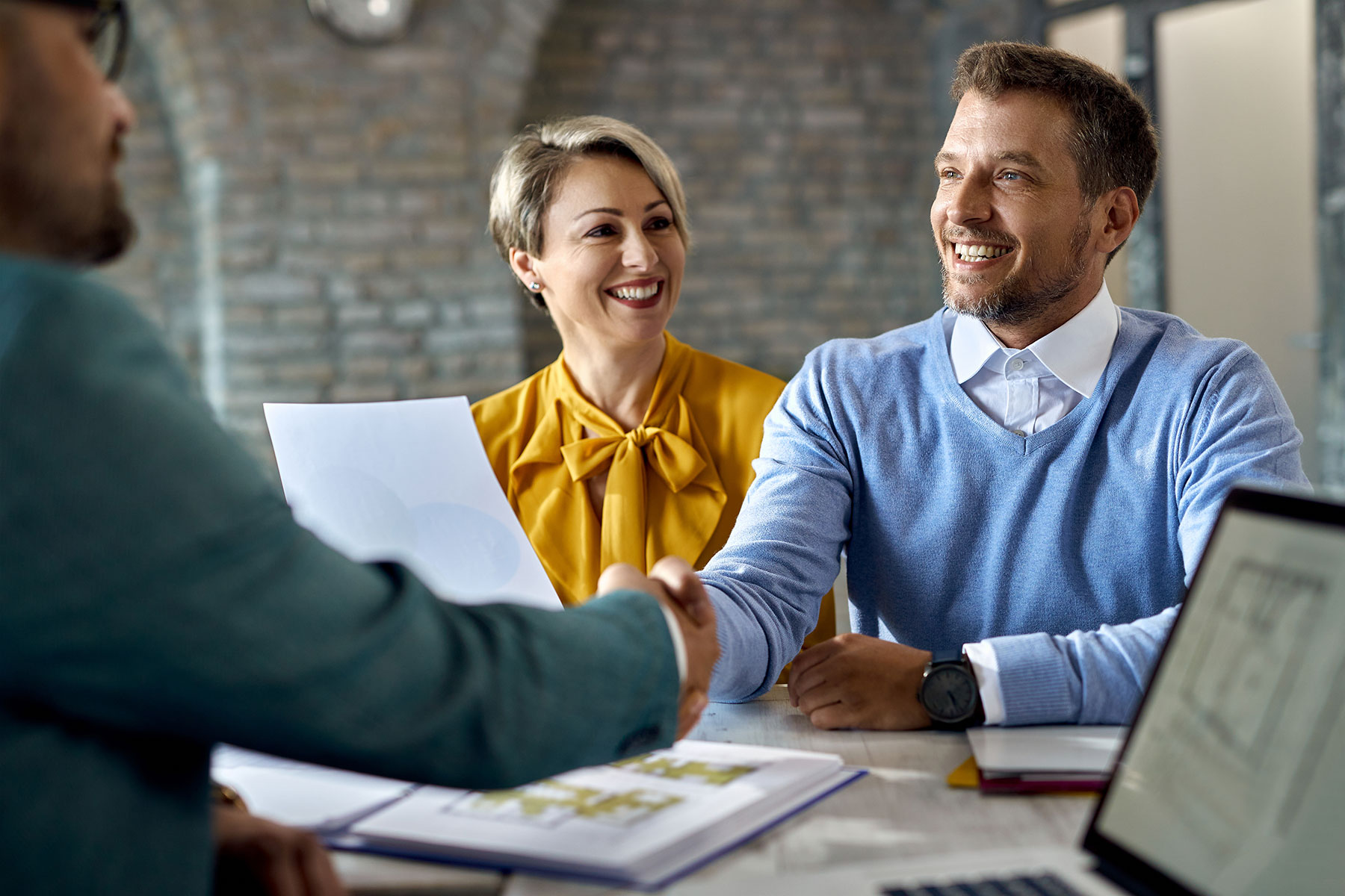 Business owners shaking hands with new salesperson after successful job interview