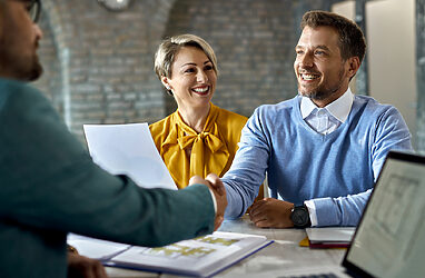 Business owners shaking hands with new salesperson after successful job interview